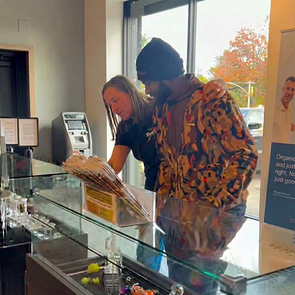 SeshNYC Budtender Helping a Customer Select Cannabis Products in a Glass Display